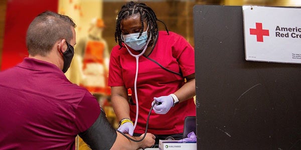 American Red Cross worker draws blood for donation.